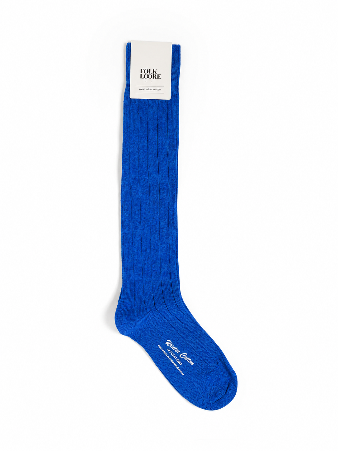 A single royal blue ribbed knee-high sock with a white paper brand tag at the cuff, displayed on a clean white background. socks, cotton socks, high-knee socks, made in italy, handmade, artigianally made, fatto a mano, calzettoni invernali, winter cotton, calze di cotone, calze di cachemire, cachemire socks, cashmire socks