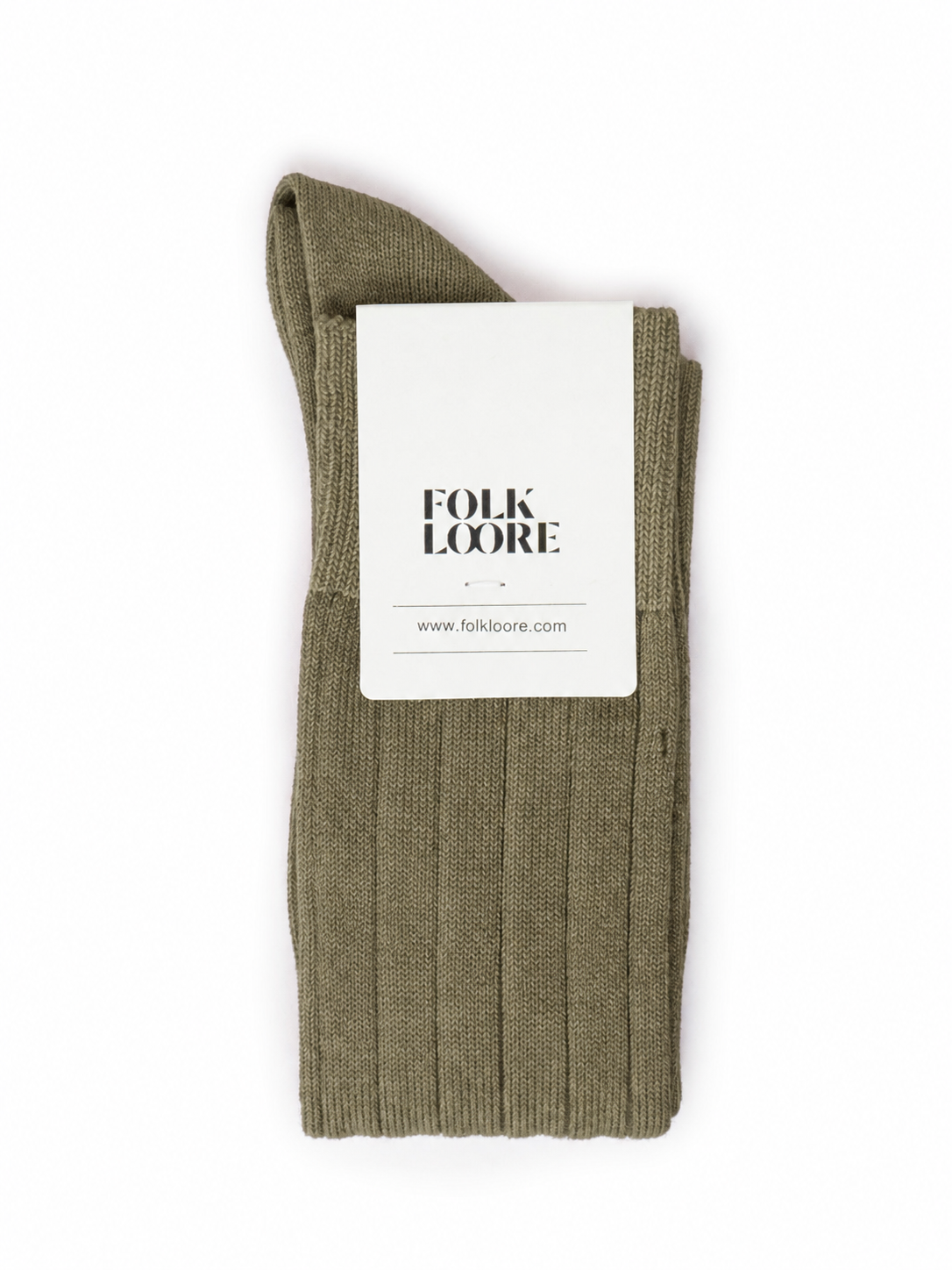 A single ribbed knit sock in olive green, folded with a white paper brand tag that reads 'FOLK LOORE' and 'www.folklore. socks, cotton socks, high-knee socks, made in italy, handmade, artigianally made, fatto a mano, calzettoni invernali, winter cotton, calze di cotone, calze di cachemire, cachemire socks, cashmire socks