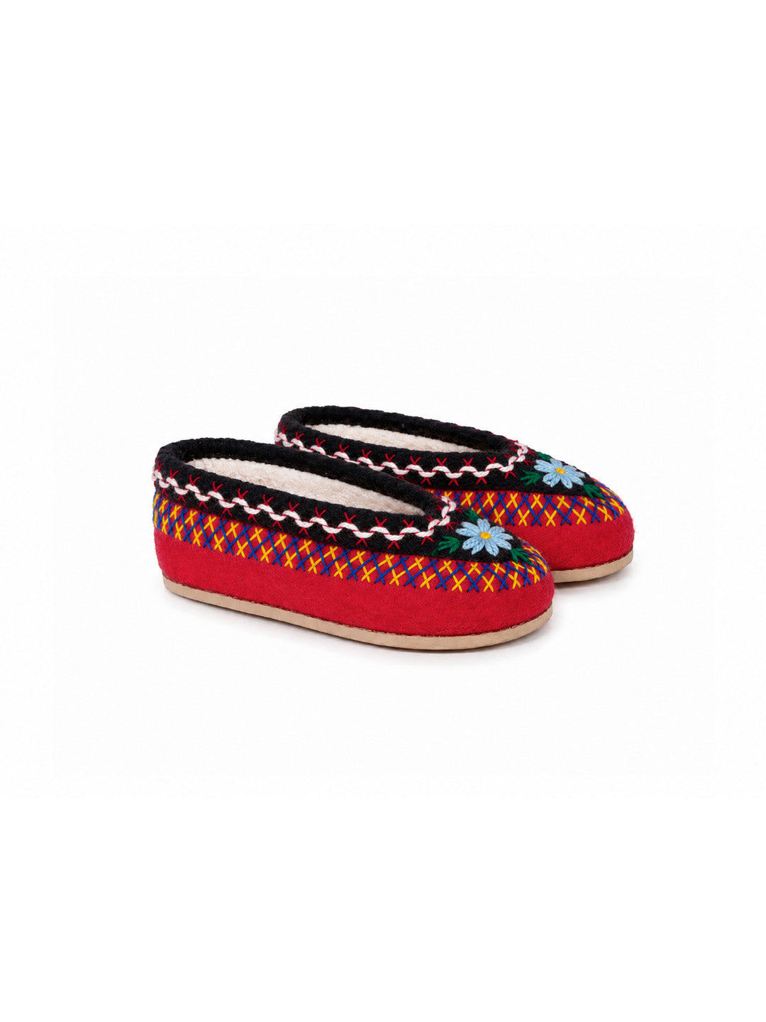 A pair of red knit slip-on slippers with black trim, a colorful geometric pattern, and a small blue and white flower detail on the toe, shown against a plain white background. POLISH SLIPPERS, FELT SLIPPERS, WINTER SLIPPERS, WOOL SLIPPERS, EMBROIDERED SLIPPERS, COZY SLIPPERS, WINTER TIME, PANTOFOLE POLACCHE, TRADITIONAL SLIPPERS, MATCHY SLIPPERS, MUM AND ME, PANTOFOLE DI FELTRO, PANTOFOLE DI LANA, PANTOFOLE RICAMATE, PANTOFOLE INVERNALI, PANTOFOLE RICAMATE, HAND MADE, FATTO A MANO, ARTIGIANALE